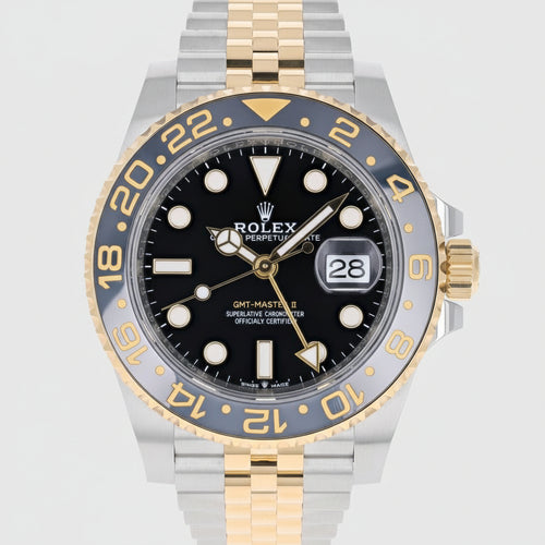 Rolex watch with black dial and gold and silver case on a white background