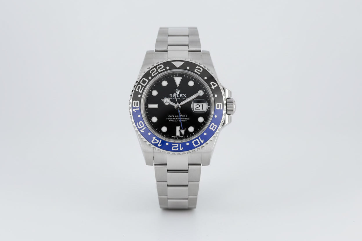 Rolex watch with black face and blue bezel on a white background