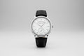 Watch with black leather strap and silver case on a white background